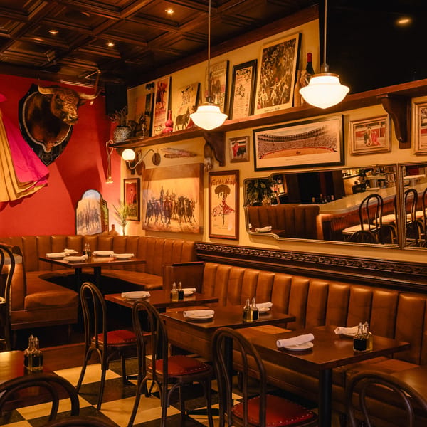 Romesco Mexiterranean Bistro interior with brown leather booths, dark wood tables, and bullfighting decor.