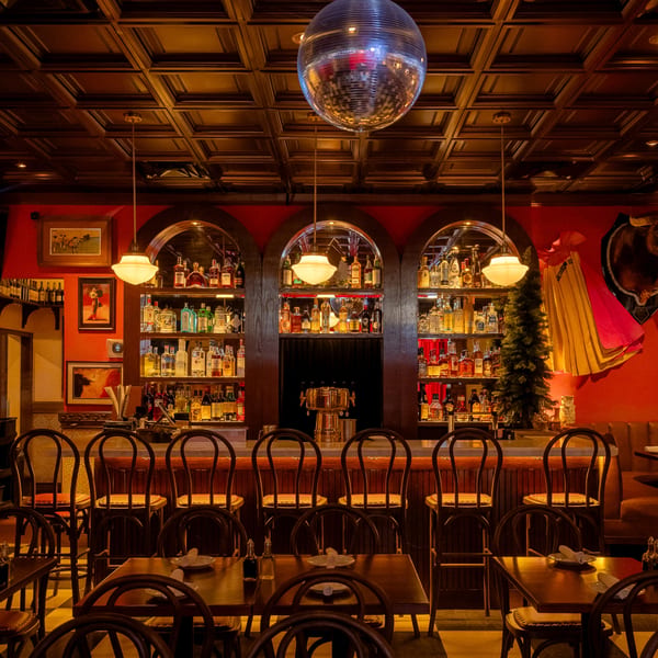 Romesco Mexiterranean Bistro's bar area with a disco ball, liquor shelves, and dining tables.
